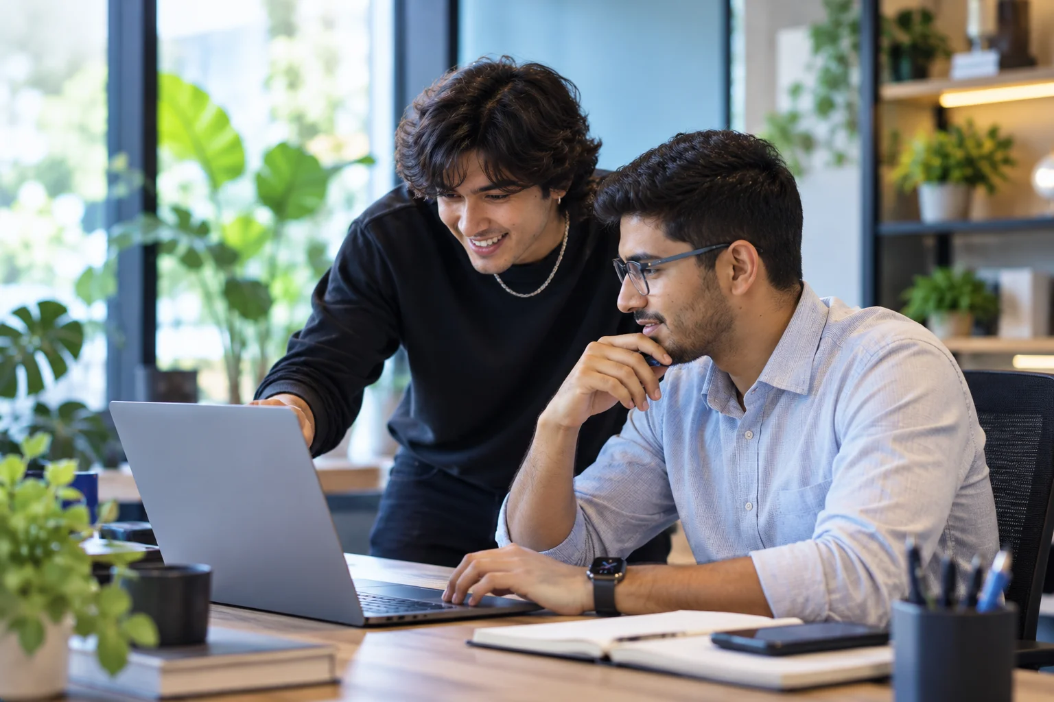 Two colleagues reviewing bookings together on a laptop at a boutique workspace